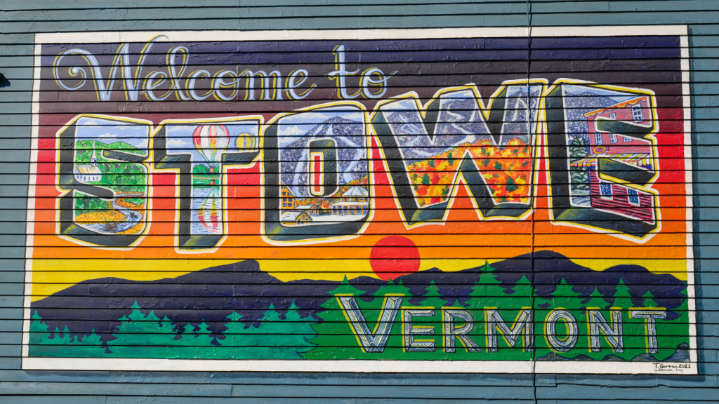 Welcome to Stowe mural by Tara Goreau on the Laughing Moon Chocolates building in downtown Stowe Vermont